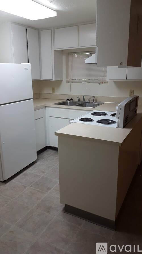 A kitchen with white appliances and a white refrigerator.