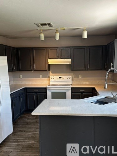A kitchen with a white fridge and a white counter top.