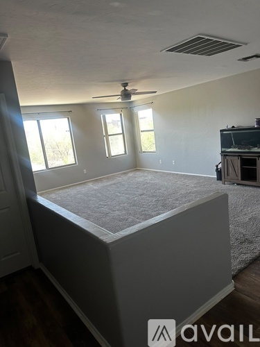 A bedroom with a bed, a ceiling fan, and a television.