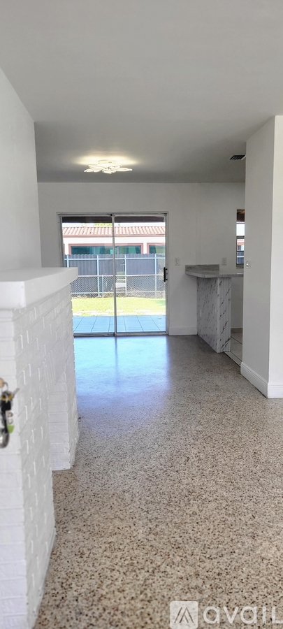 A spacious room with a large window and a tiled floor.