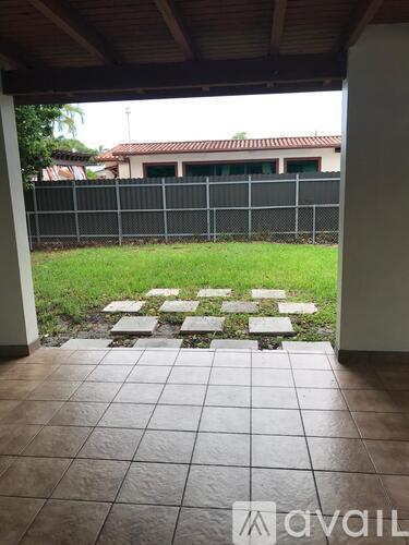 A patio with a tiled floor and a garden area with stepping stones.