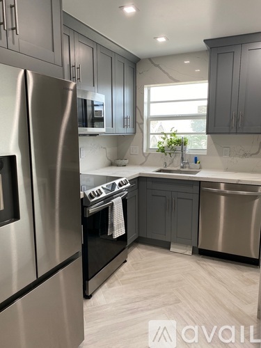 A kitchen with a stainless steel refrigerator and a dishwasher.