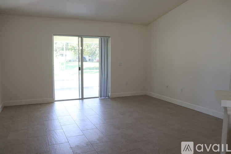 A room with a sliding glass door and tiled floor.