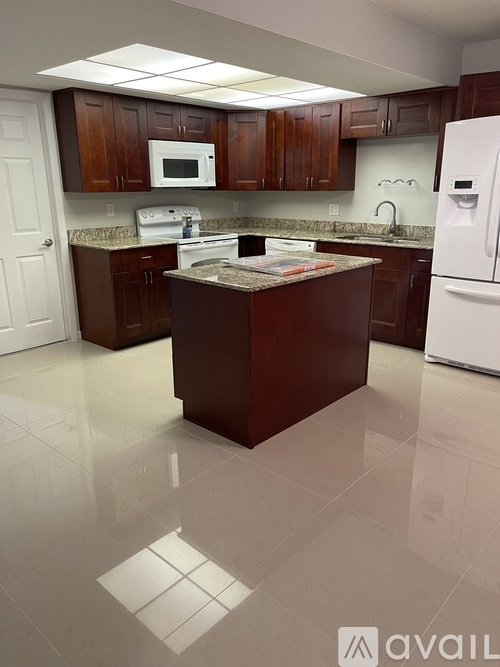 A kitchen with brown cabinets and a white fridge.