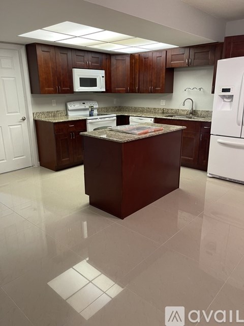 A kitchen with brown cabinets and a white fridge.