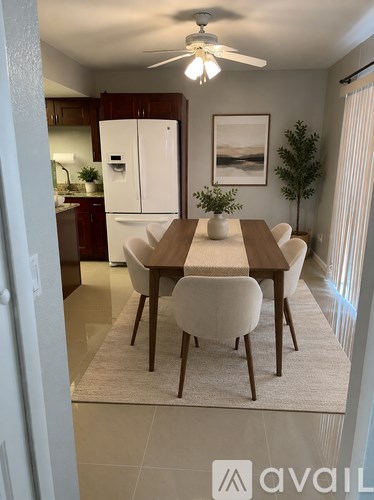 A dining room with a table and chairs.