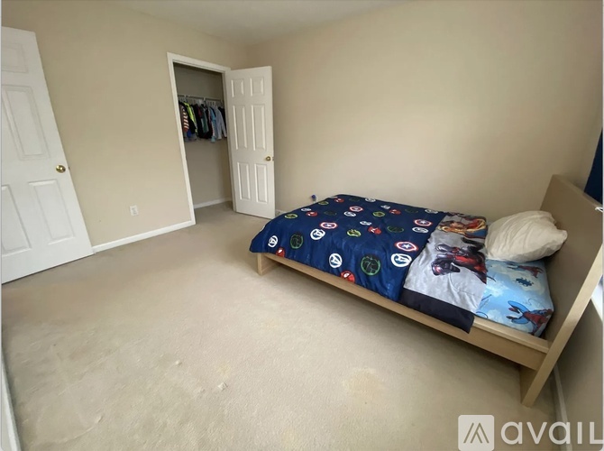 A bedroom with a bed, pillow, and a blanket with a blue pattern.
