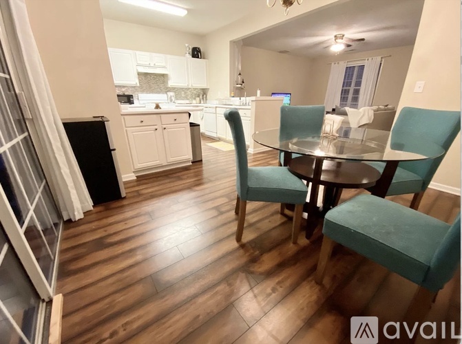 A kitchen with a table and chairs in the foreground.