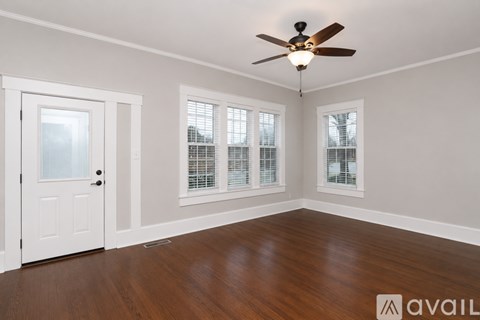 A room with a ceiling fan and wooden flooring.