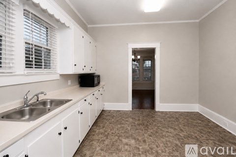 A kitchen with white cabinets and a sink.