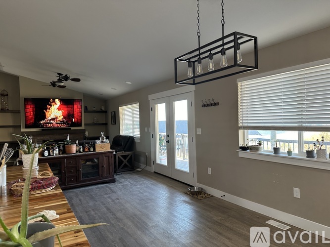 A modern kitchen with a wooden table and a flat screen TV mounted above the fireplace.