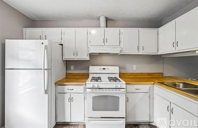 A kitchen with white appliances and cabinets.