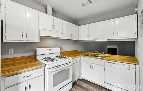 A kitchen with white cabinets and a wooden countertop.