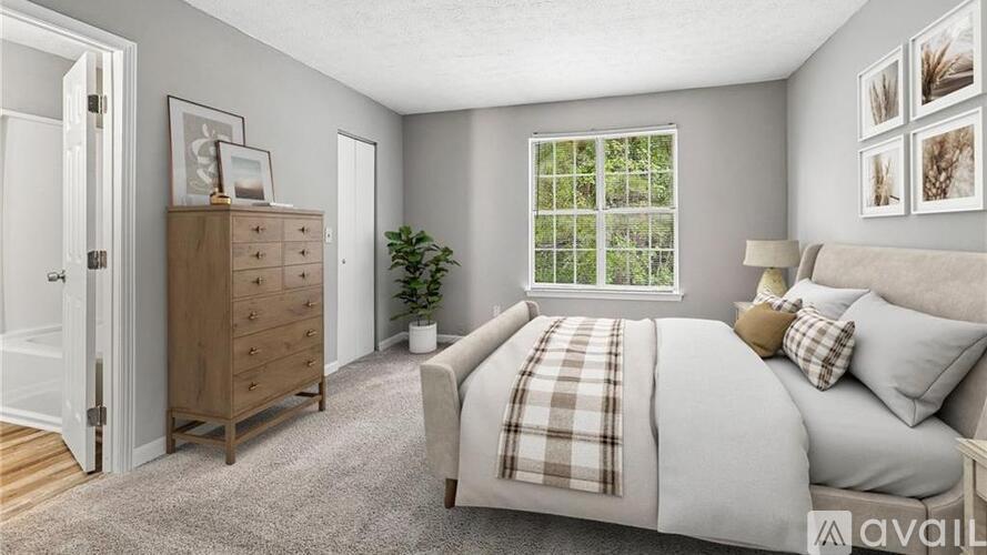A bedroom with a bed, dresser, and window.