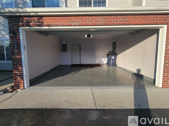 A garage with a white door and a red brick wall.