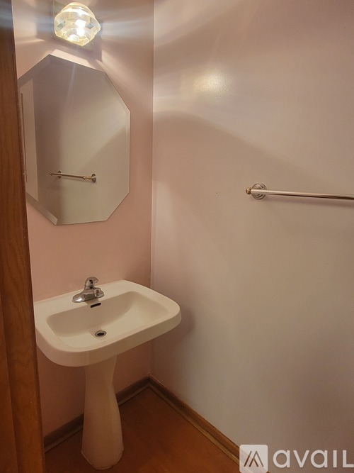 A white pedestal sink in a small bathroom.