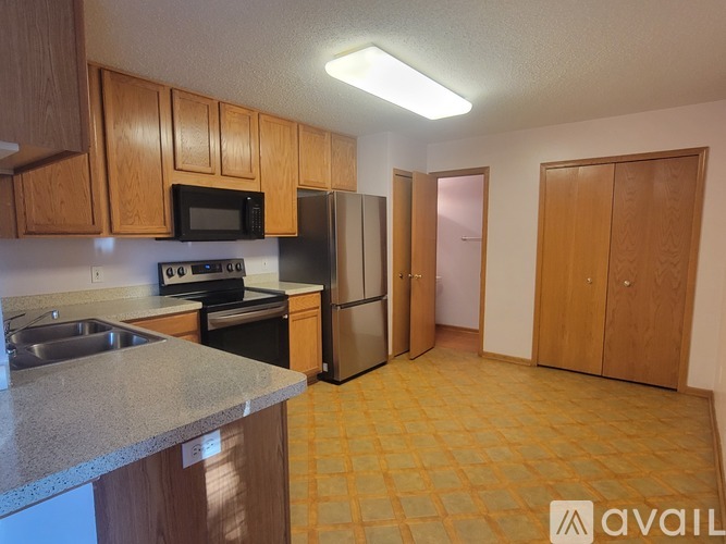 A kitchen with wooden cabinets and a granite countertop.