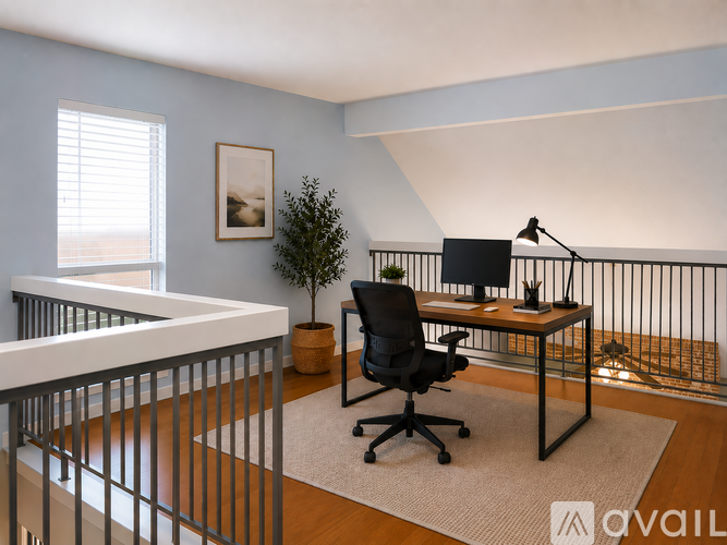 A room with a desk, chair, and a plant.