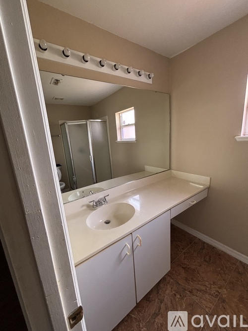 A bathroom with a white sink and a mirror.