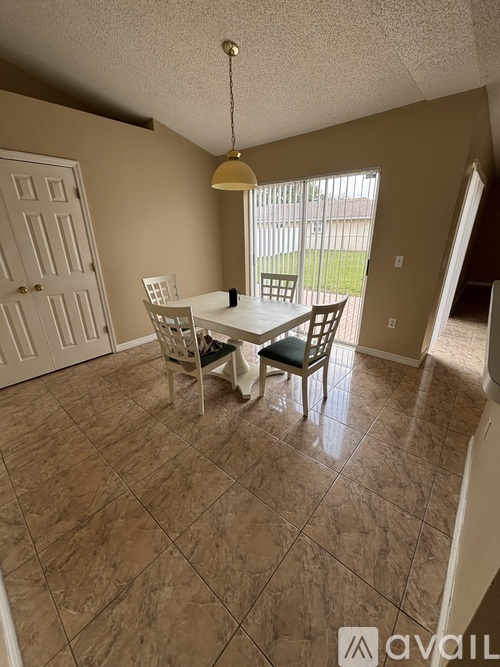 A dining room with a table and chairs.