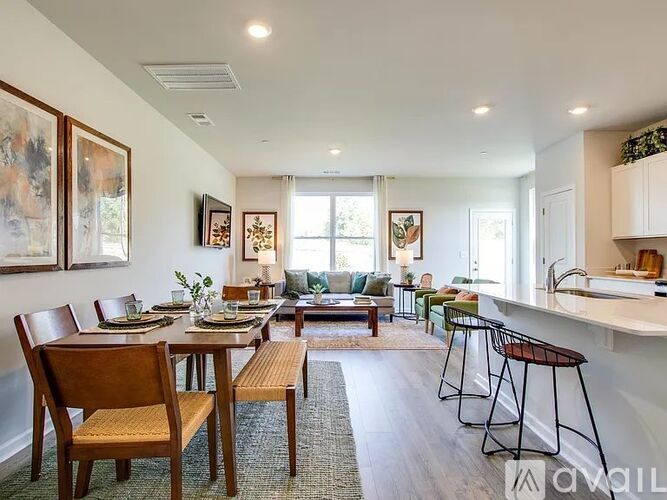 A dining room with a table set for four and chairs around it.