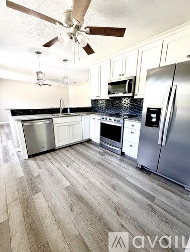 A kitchen with a refrigerator, oven, and microwave.