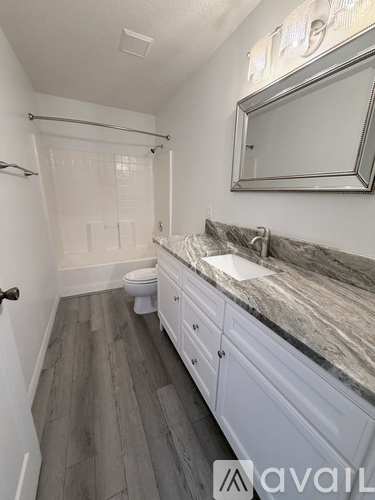 A bathroom with a marble countertop and a white toilet.