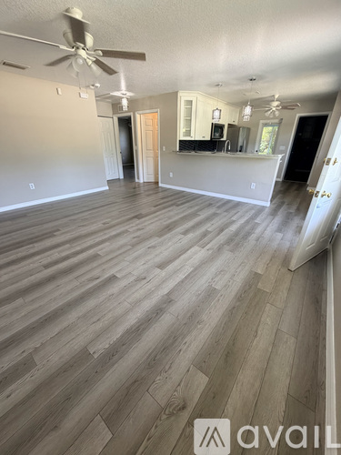 A room with wooden flooring and a ceiling fan.