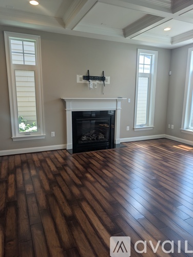 A living room with a fireplace and wood flooring.