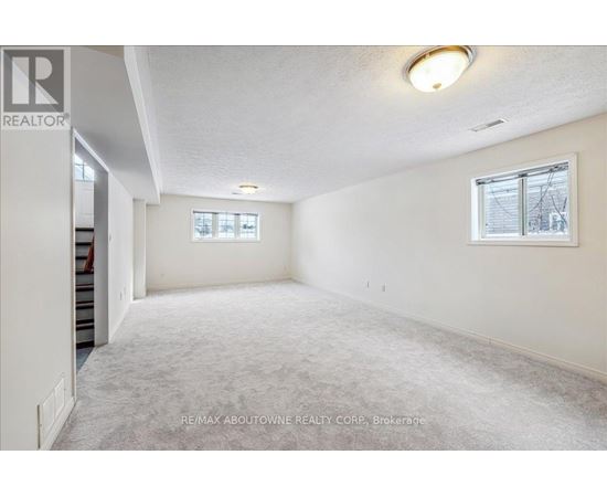 A spacious room with a carpeted floor and a window with blinds.