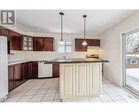 A kitchen with brown cabinets and a white dishwasher.