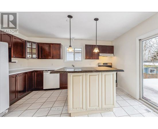 A kitchen with brown cabinets and a white dishwasher.