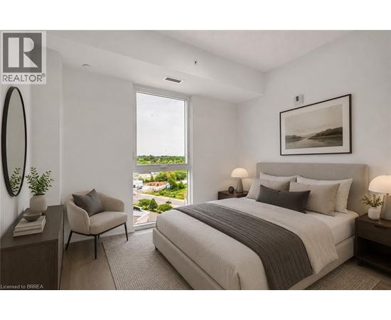 A bedroom with a large bed and a view of the outdoors through a window.