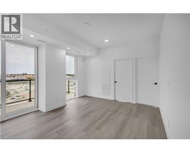 A spacious room with wooden flooring and white walls.