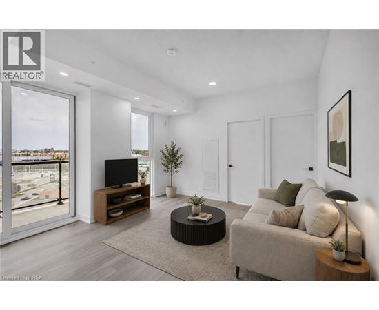 A living room with a couch, a television, and a plant.