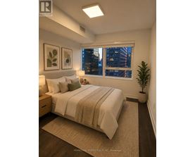 A bedroom with a large bed and a window overlooking a cityscape.