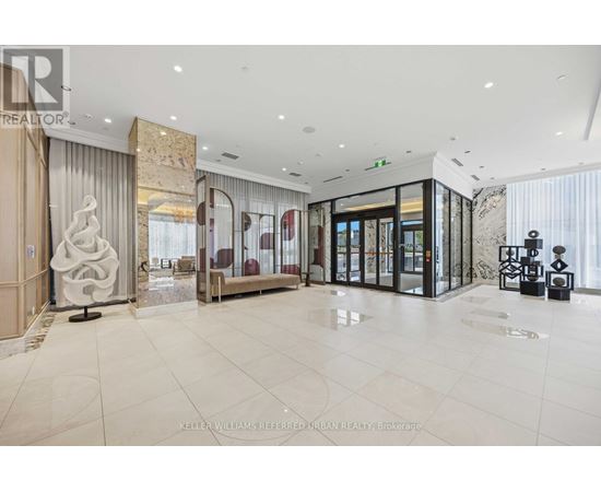 A spacious, well-lit lobby with a marble floor and modern furnishings.