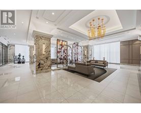 A spacious living room with a marble floor and a chandelier.
