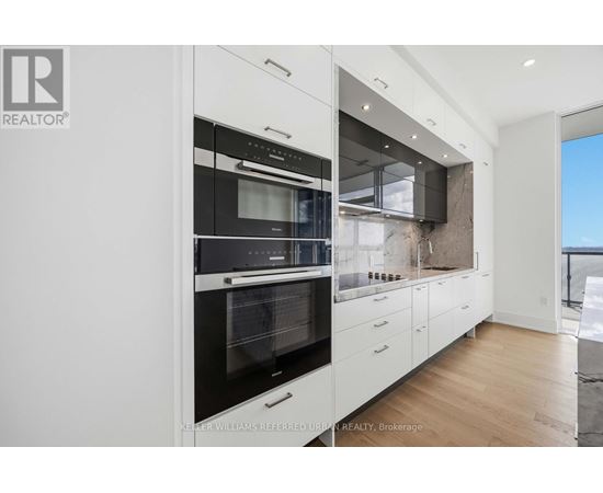 A modern kitchen with white cabinets and a black oven.