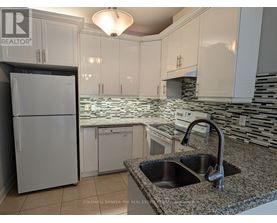 A kitchen with granite countertops and white cabinets.