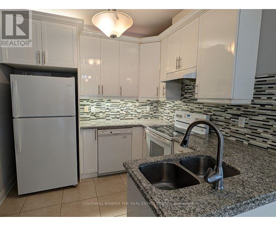 A kitchen with granite countertops and white cabinets.