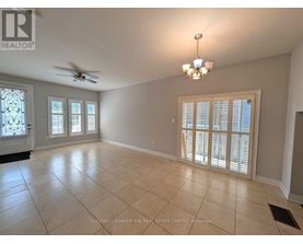 A spacious room with a ceiling fan and a chandelier.