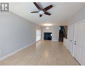 A spacious room with a ceiling fan and light fixture.