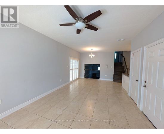 A spacious room with a ceiling fan and light fixture.