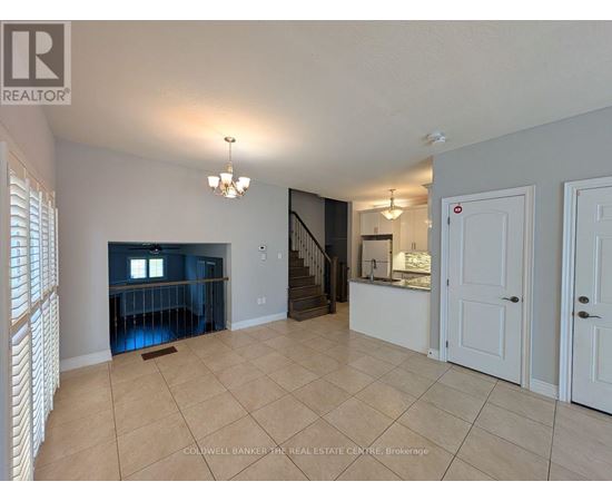 A spacious room with a staircase leading to the upper floor.