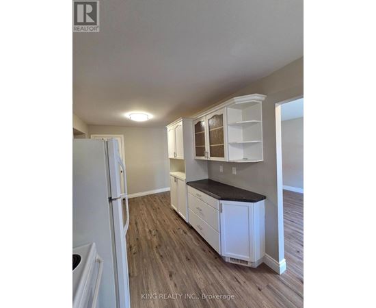 A kitchen with white cabinets and a black countertop.