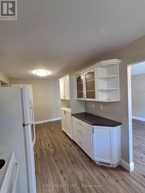 A kitchen with white cabinets and a black countertop.