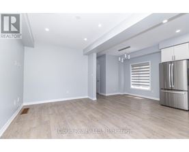 A spacious room with a refrigerator on the right side.
