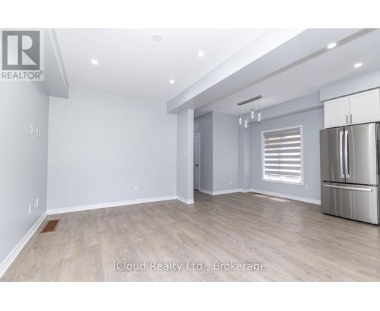 A spacious room with a refrigerator on the right side.