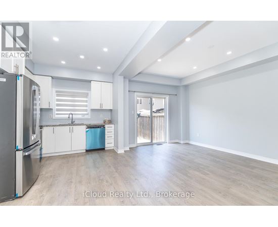 A spacious kitchen with white cabinets and a refrigerator.